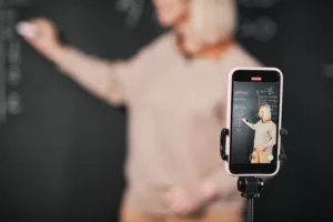 Teacher recording lesson on smartphone in class